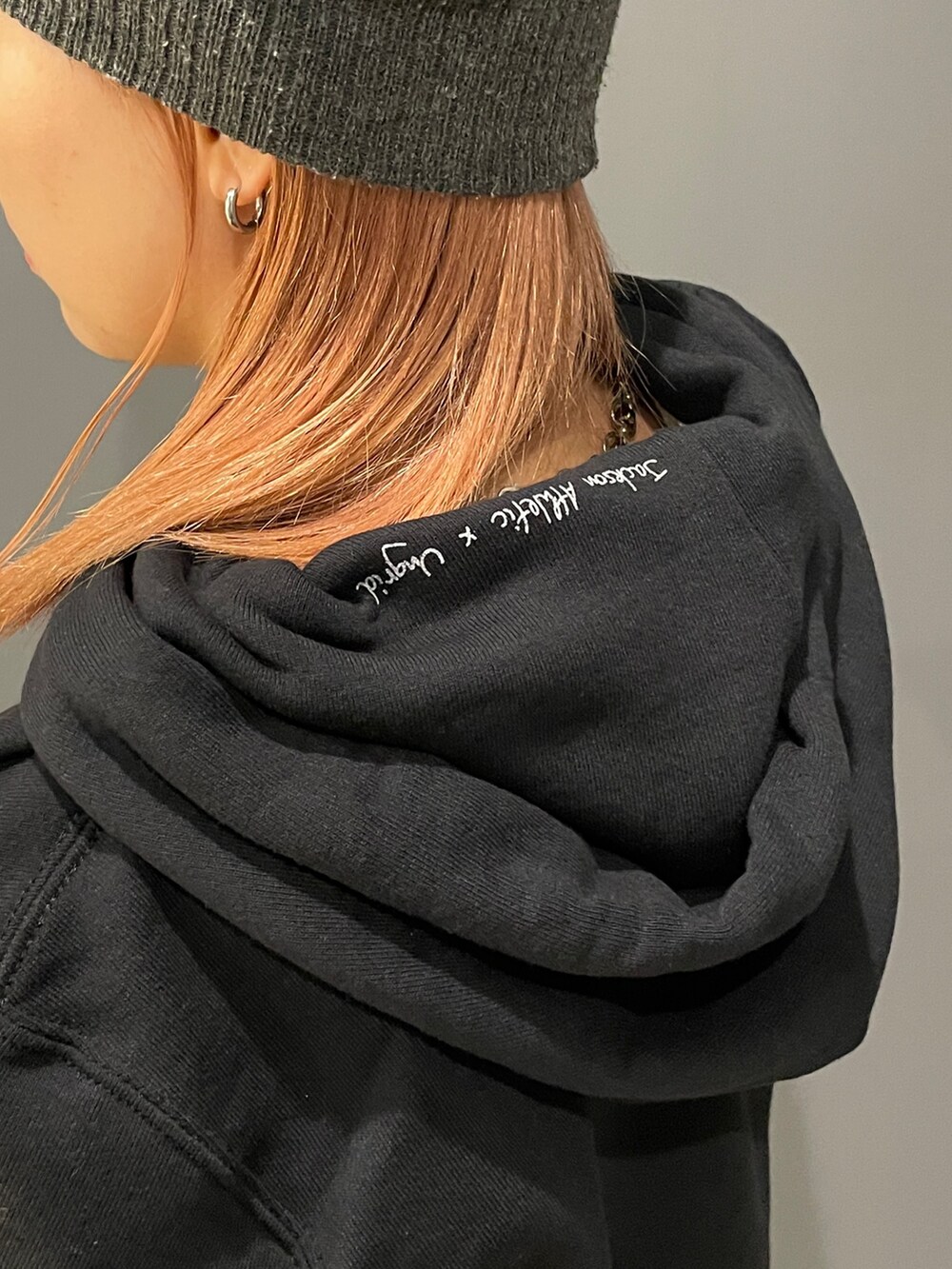 ブラック系のパーカー、ホワイト系のTシャツ/カットソー、ブラック系のデニムパンツを着用したレディースの秋コーディネートの6枚目の写真