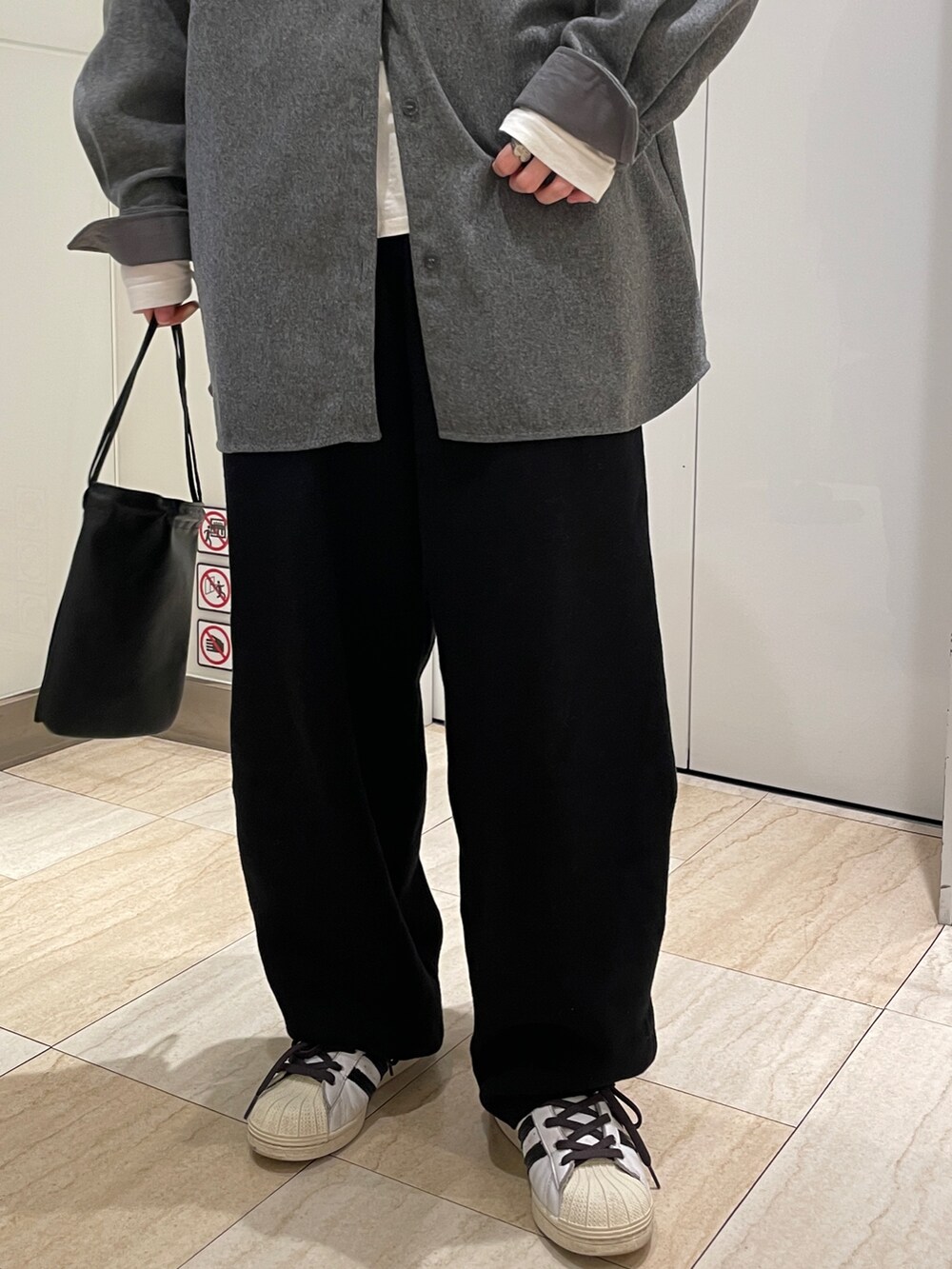 グレー系のシャツ/ブラウス、ブラック系のその他パンツ、ホワイト系のTシャツ/カットソーを着用したレディースの秋コーディネートの4枚目の写真