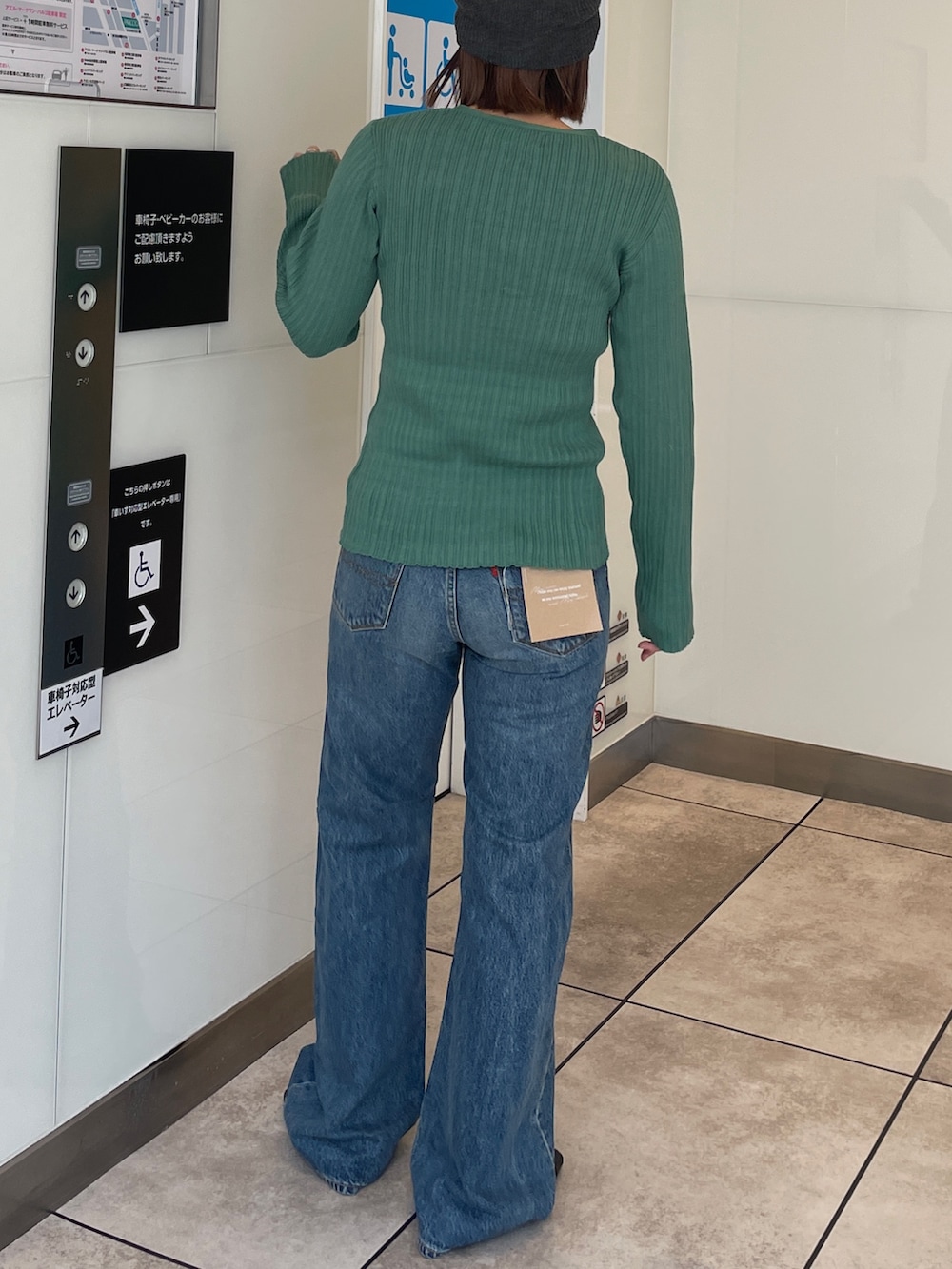 グリーン系のカーディガン/ボレロ、ブルー系のデニムパンツ、グレー系のニットキャップ/ビーニーを着用したレディースの春コーディネートの3枚目の写真