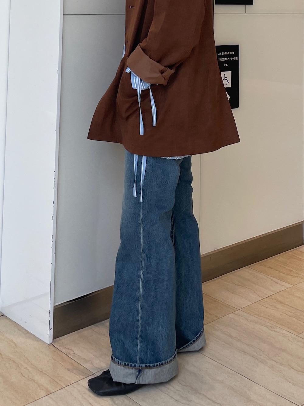 ブラウン系のテーラードジャケット、ブルー系のシャツ/ブラウス、ブルー系のデニムパンツを着用したレディースの春コーディネートの7枚目の写真