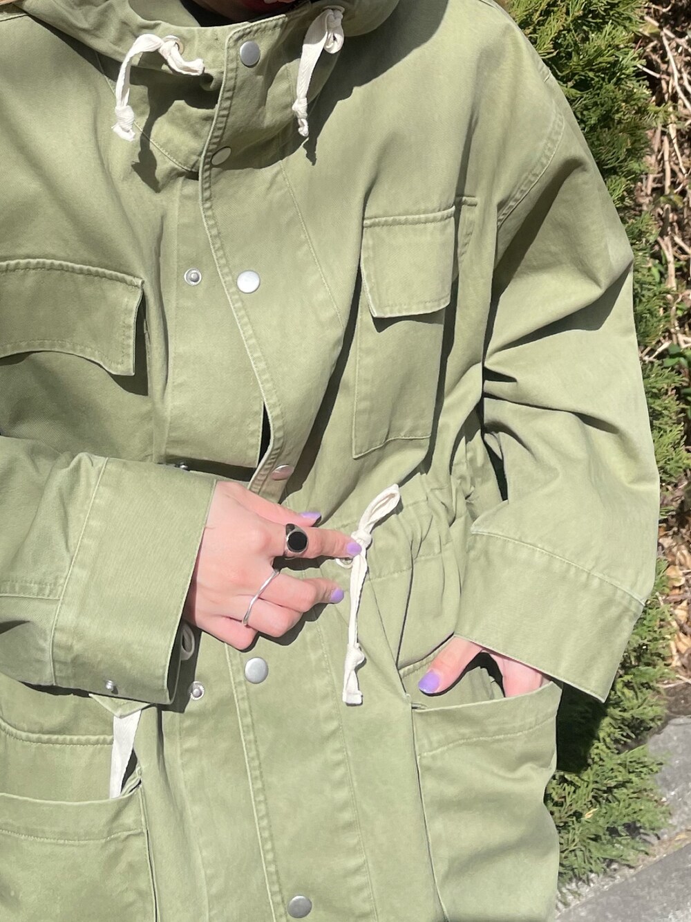 グリーン系のブルゾン、ブラック系のワンピース、ホワイト系のニットキャップ/ビーニーを着用したレディースの冬コーディネートの6枚目の写真