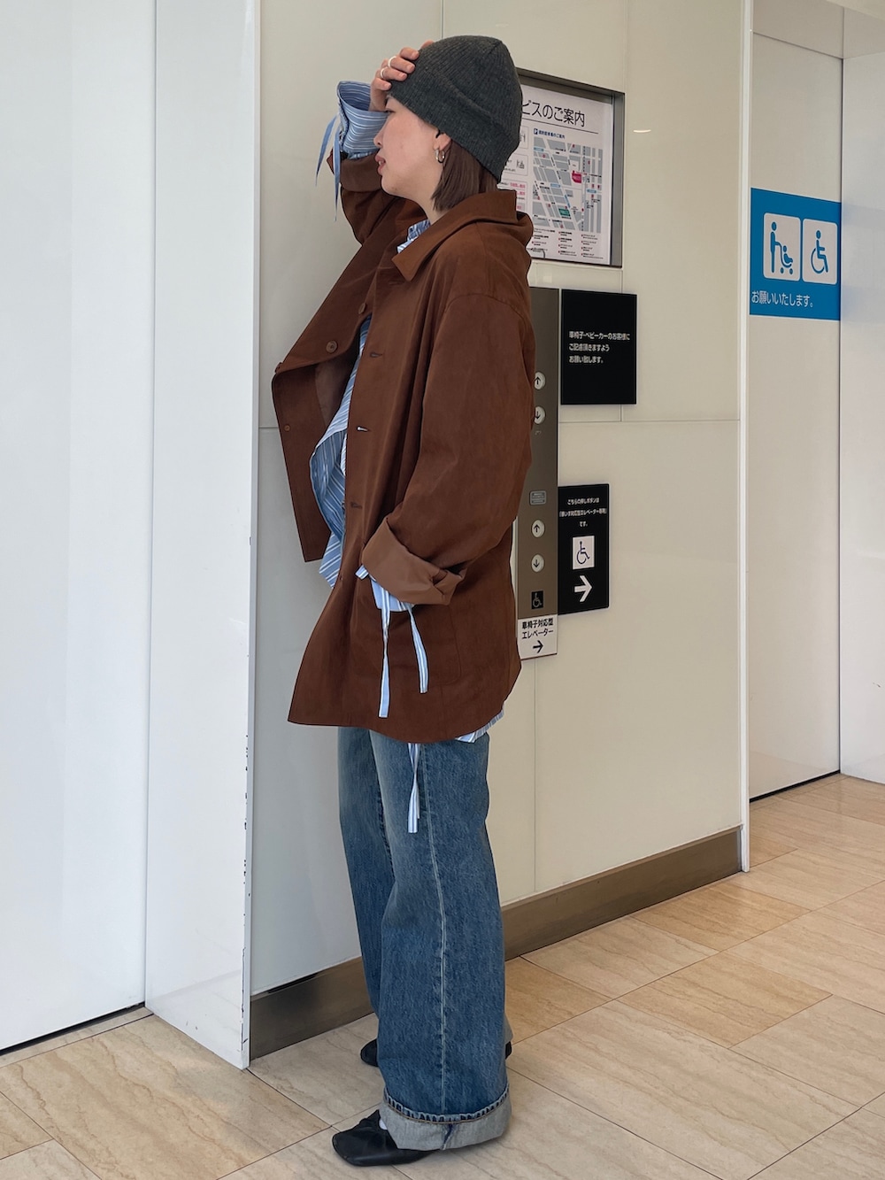 ブラウン系のテーラードジャケット、ブルー系のシャツ/ブラウス、ブルー系のデニムパンツを着用したレディースの春コーディネートの2枚目の写真