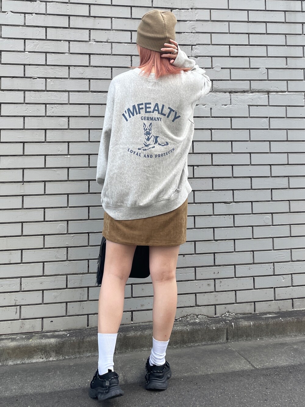 グレー系のスウェット、ベージュ系のスカート、ブラック系のハンドバッグを着用したレディースの秋コーディネートの3枚目の写真