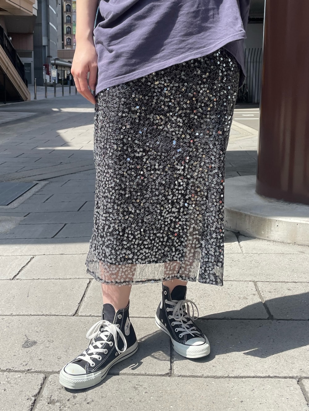 ブルー系のTシャツ/カットソー、ブラック系のスカート、ゴールド系のネックレスを着用したレディースの春コーディネートの5枚目の写真