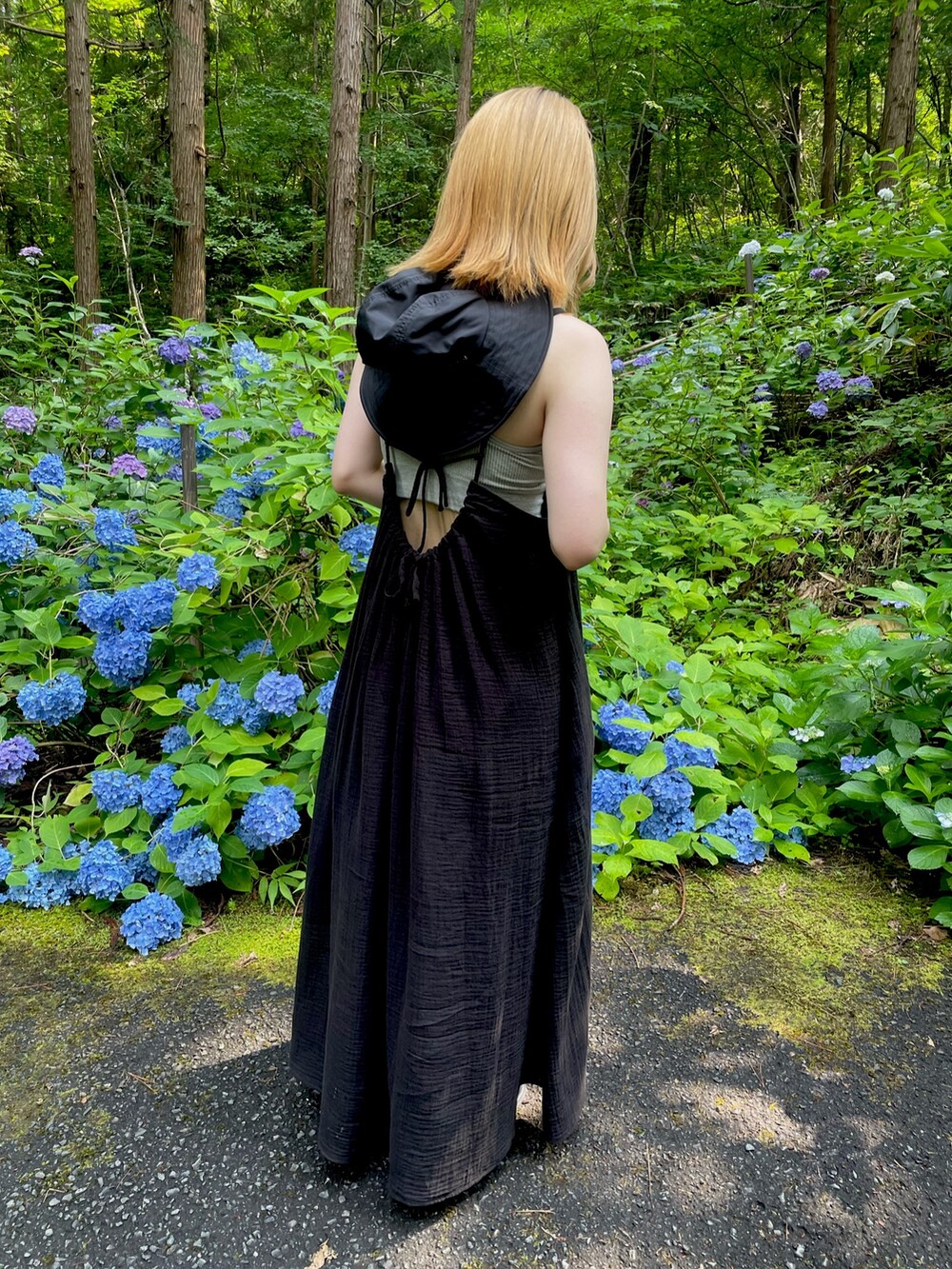 ブラック系のワンピース、ブルー系のデニムパンツ、ブラック系のサンダルを着用したレディースの夏コーディネートの3枚目の写真