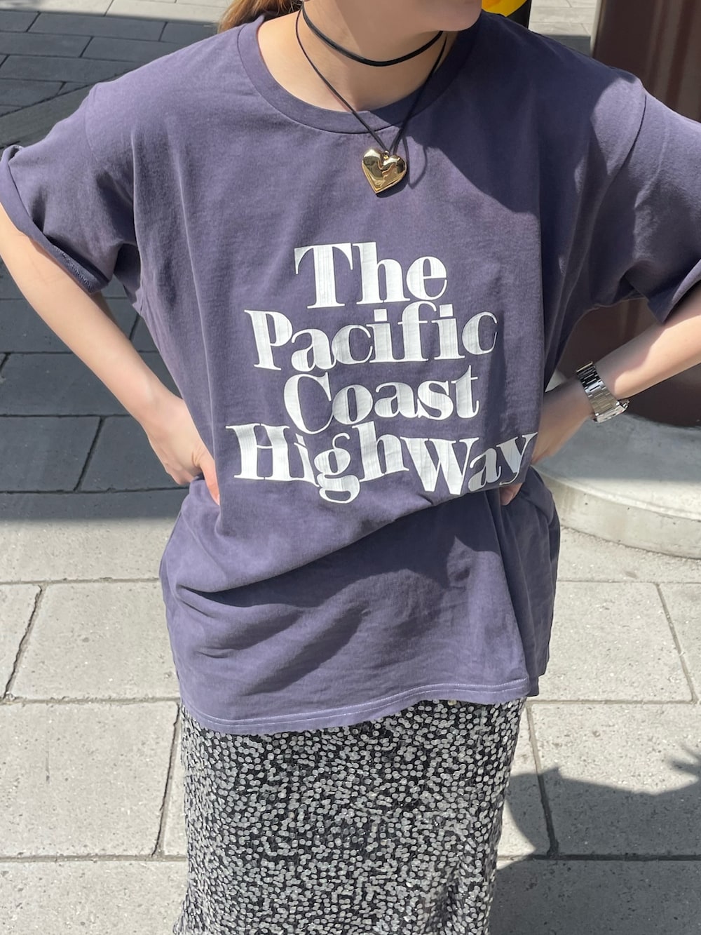 ブルー系のTシャツ/カットソー、ブラック系のスカート、ゴールド系のネックレスを着用したレディースの春コーディネートの7枚目の写真