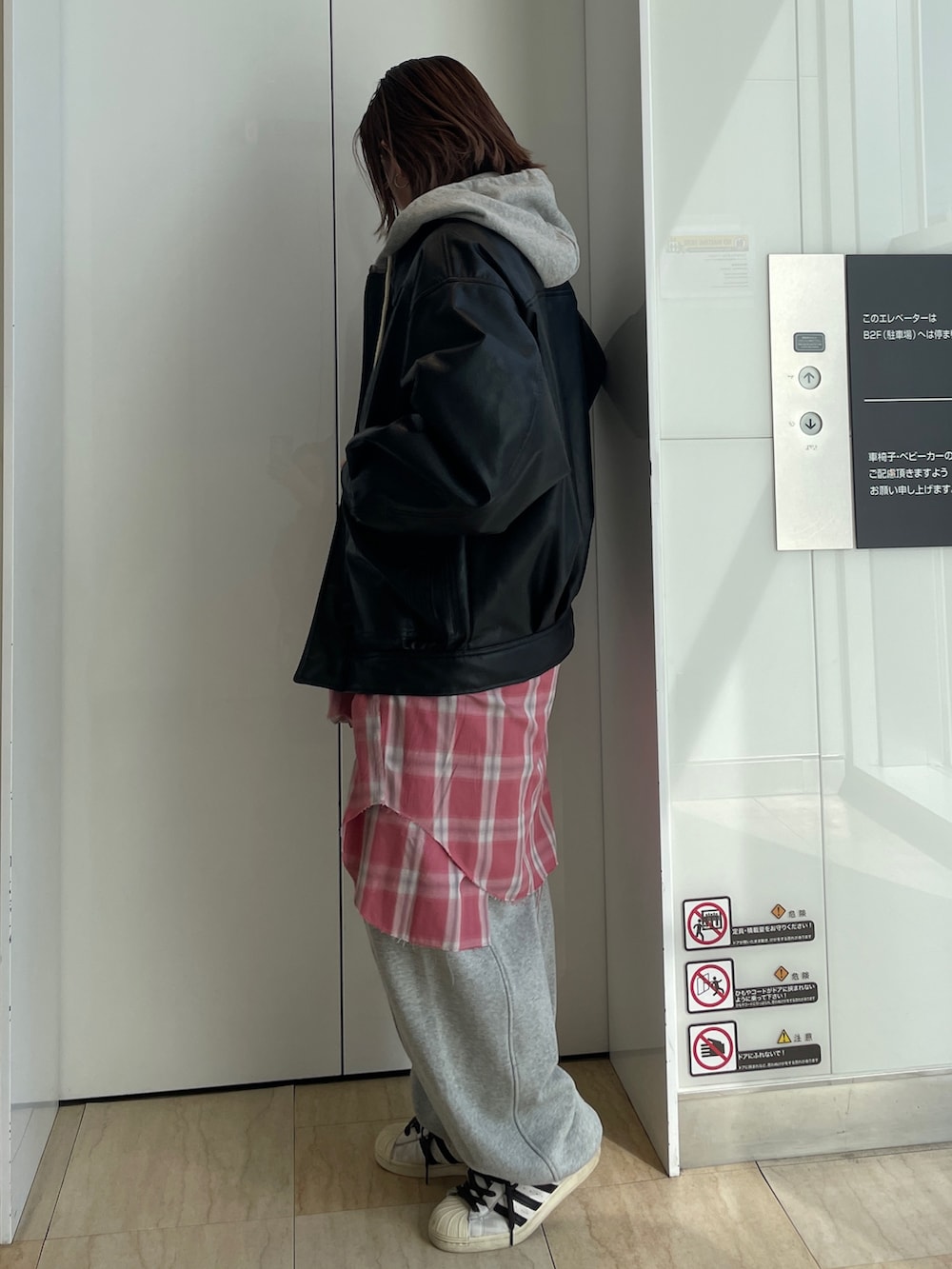 ブラック系のブルゾン、グレー系のパーカー、レッド系のシャツ/ブラウスを着用したレディースの冬コーディネートの2枚目の写真