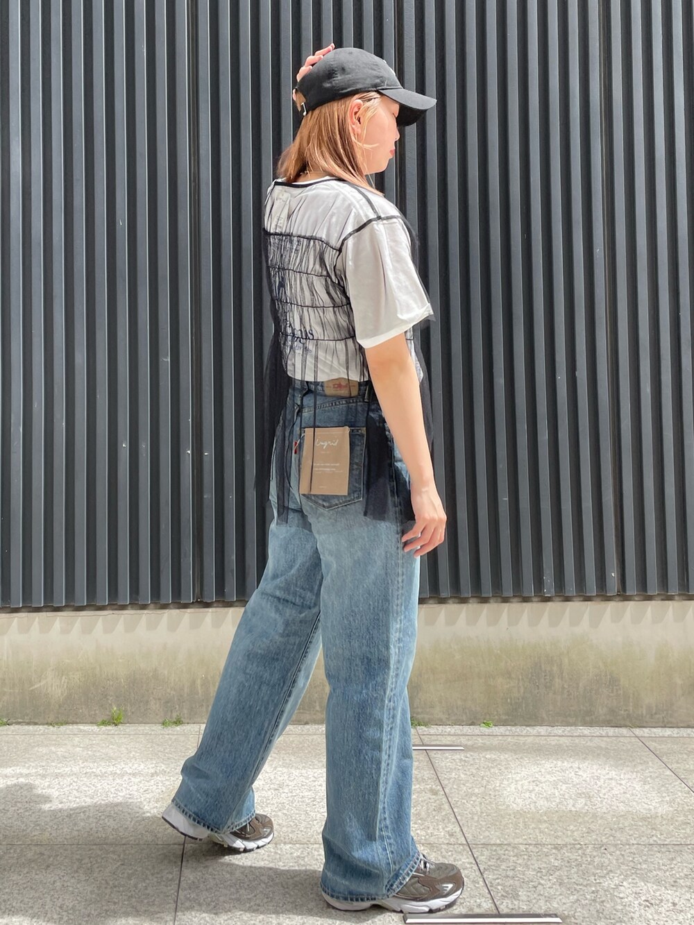 ホワイト系のTシャツ/カットソー、ブラック系のTシャツ/カットソー、ブルー系のデニムパンツを着用したレディースの春コーディネートの2枚目の写真