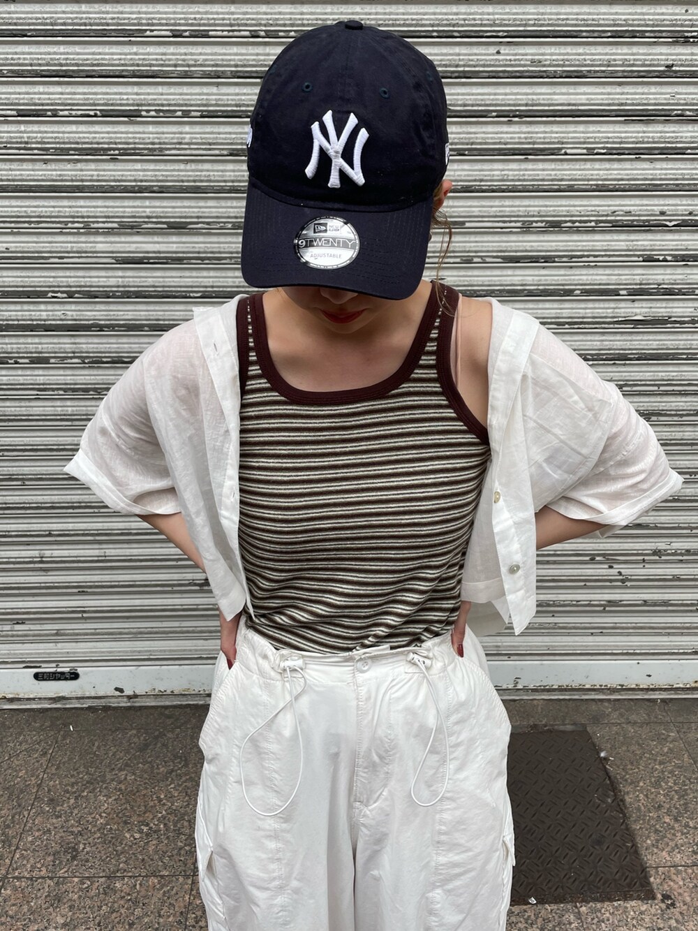 ホワイト系のカーゴパンツ、ブラウン系のタンクトップ、ホワイト系のシャツ/ブラウスを着用したレディースの夏コーディネートの3枚目の写真