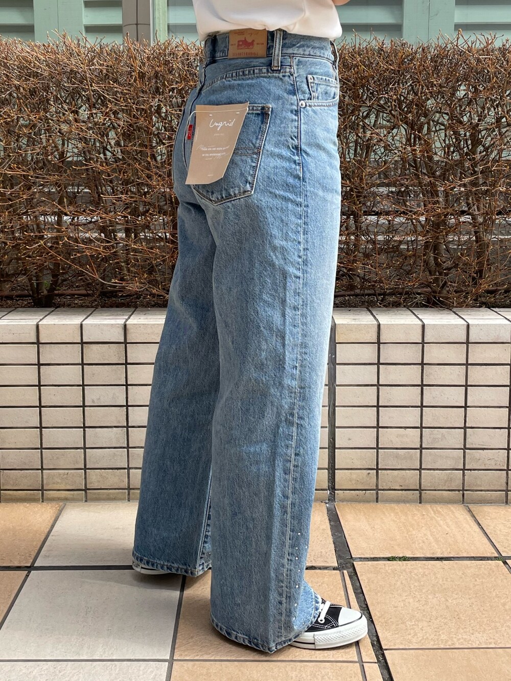 ブルー系のデニムパンツ、ホワイト系のTシャツ/カットソー、シルバー系のネックレスを着用したレディースの春コーディネートの6枚目の写真