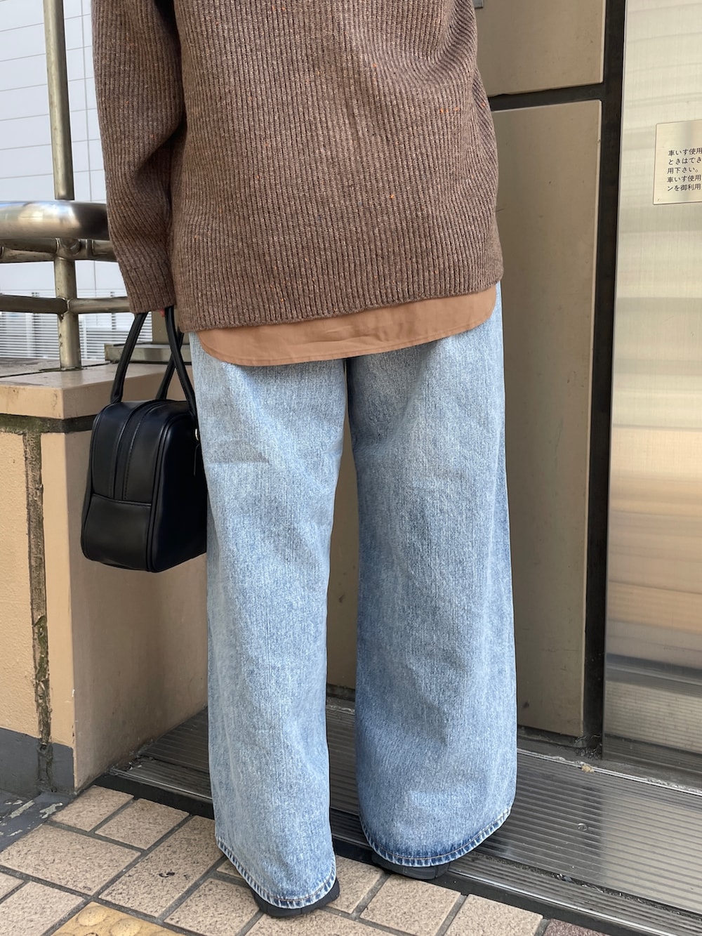 ブラウン系のカーディガン/ボレロ、ブルー系のデニムパンツ、ブラック系のハンドバッグを着用したレディースの秋コーディネートの9枚目の写真