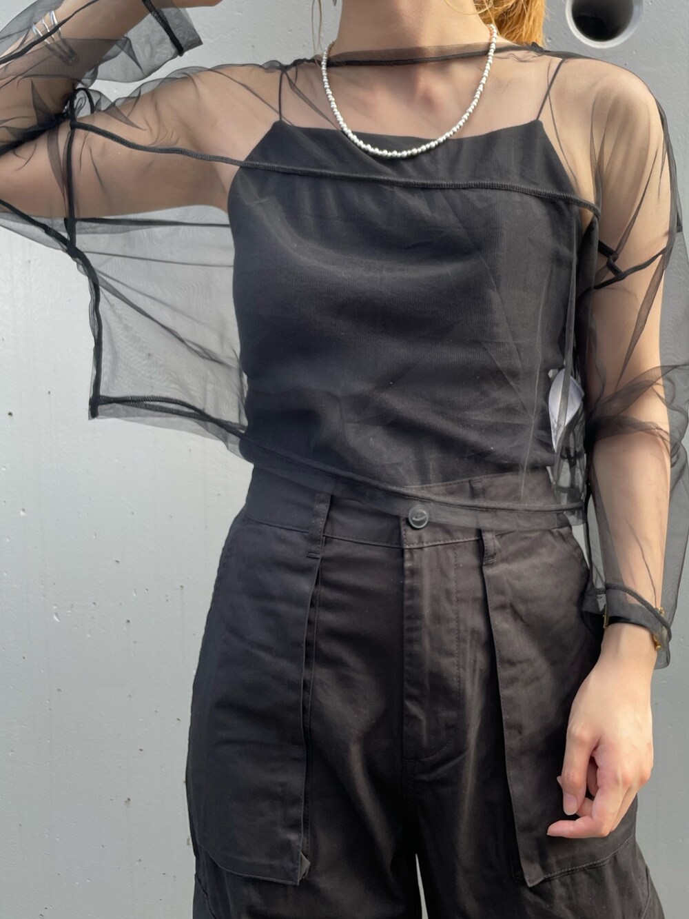 ブラック系のカーゴパンツ、ブラック系のTシャツ/カットソー、ブラック系のキャミソールを着用したレディースの夏コーディネートの3枚目の写真