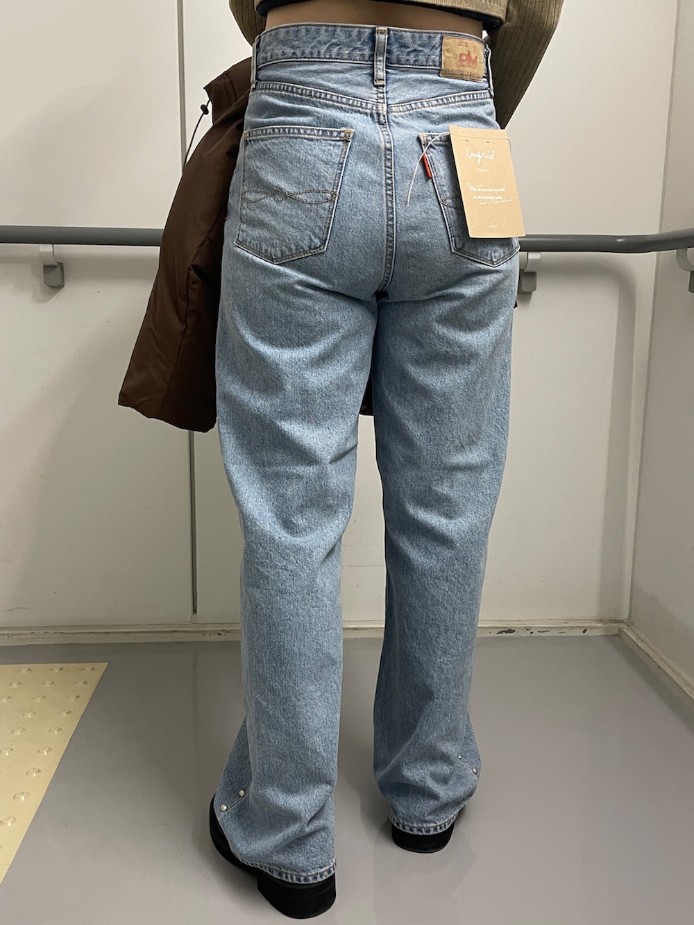 ブルー系のデニムパンツ、ブラック系のブーツ、ブラウン系のダウンジャケット/コートを着用したレディースの秋コーディネートの9枚目の写真