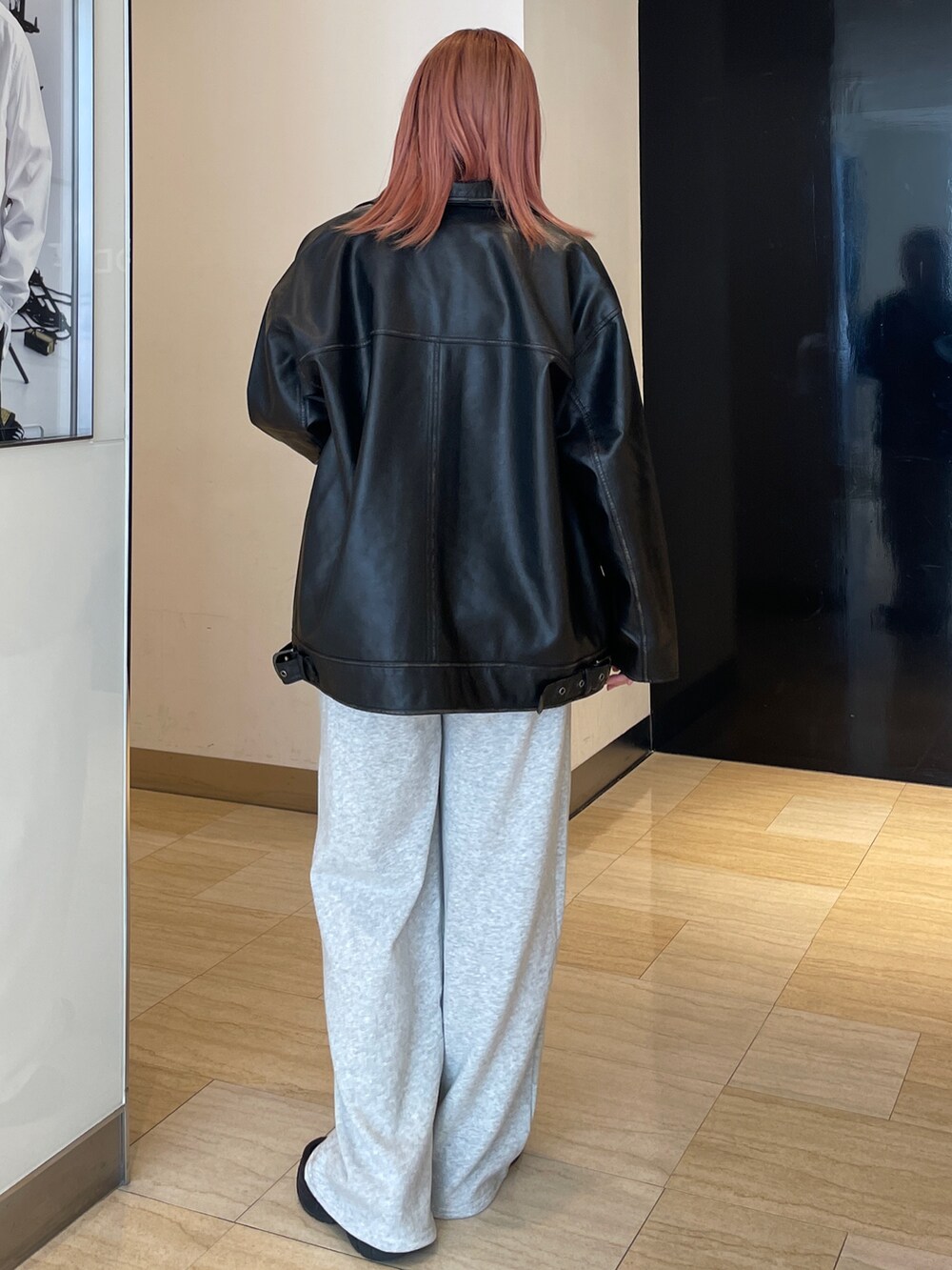 ブラック系のブルゾン、ブラウン系のニット/セーター、グレー系のスウェットパンツを着用したレディースの秋コーディネートの3枚目の写真