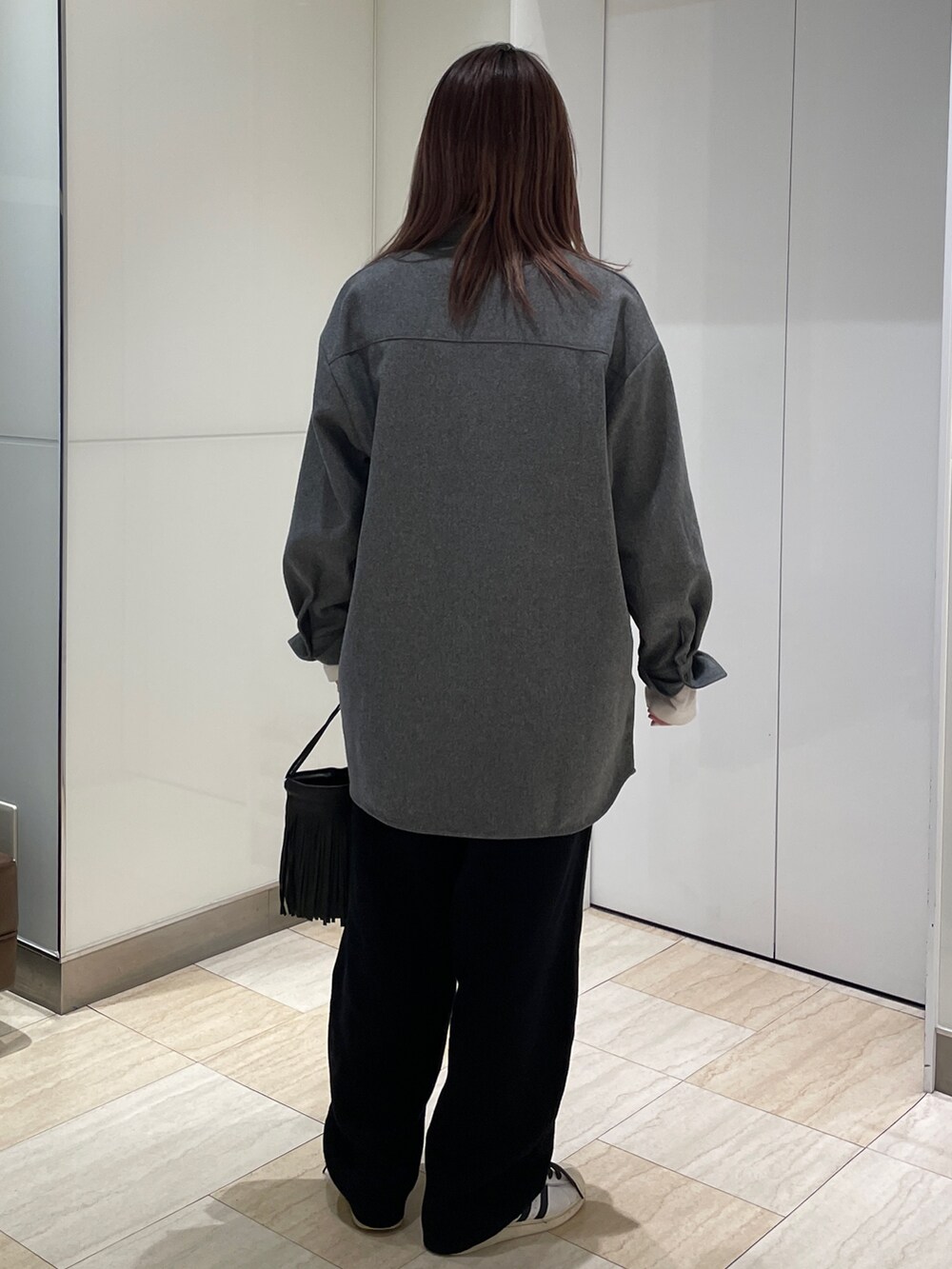 グレー系のシャツ/ブラウス、ブラック系のその他パンツ、ホワイト系のTシャツ/カットソーを着用したレディースの秋コーディネートの3枚目の写真