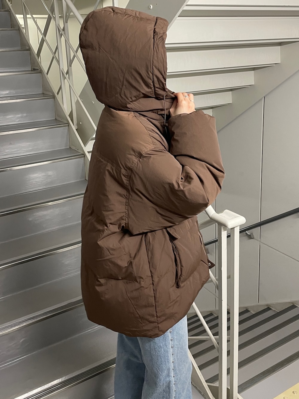 ブルー系のデニムパンツ、ブラック系のブーツ、ブラウン系のダウンジャケット/コートを着用したレディースの秋コーディネートの6枚目の写真