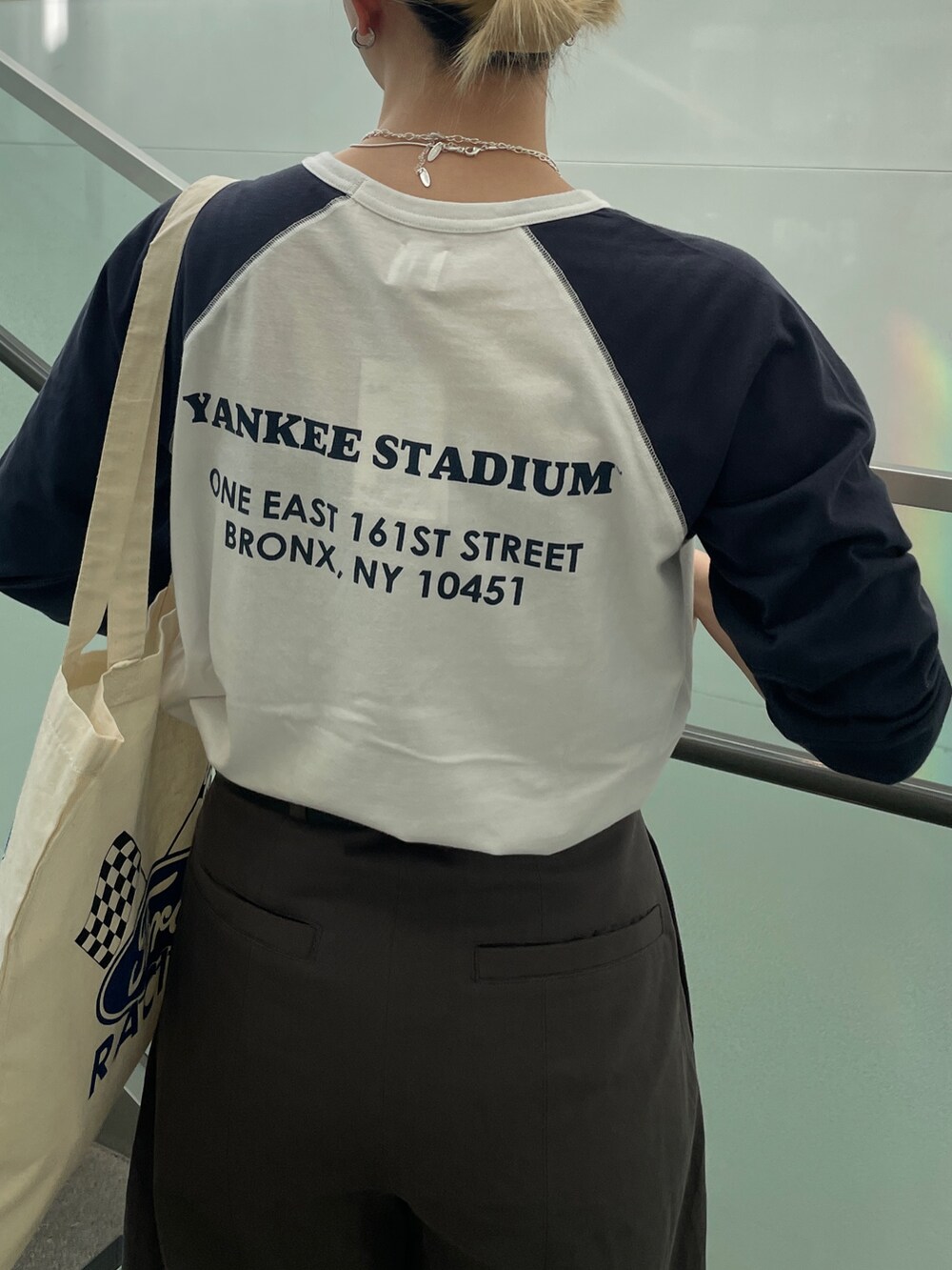 ブルー系のTシャツ/カットソー、ホワイト系のトートバッグ、グレー系のチノパンツを着用したレディースの夏コーディネートの5枚目の写真
