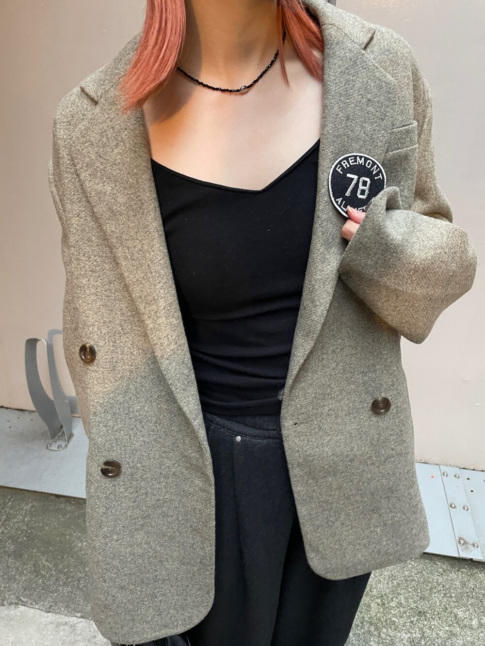 グレー系のテーラードジャケット、グレー系のスウェットパンツ、ブラック系のハンドバッグを着用したレディースの秋コーディネートの4枚目の写真