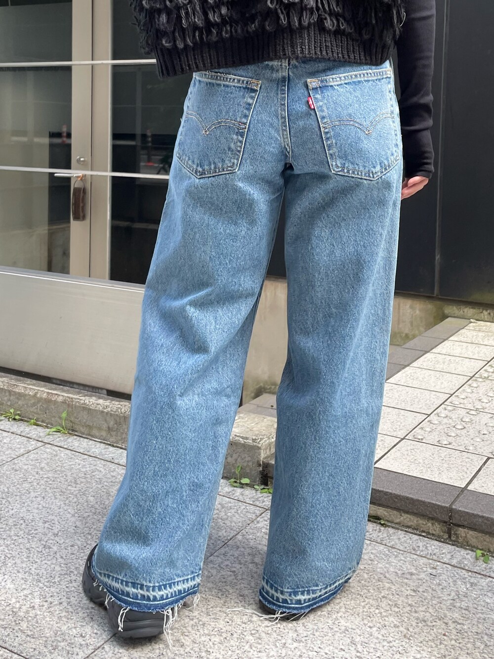 ブルー系のデニムパンツ、ブラック系のベスト、ブラック系のTシャツ/カットソーを着用したレディースの秋コーディネートの7枚目の写真