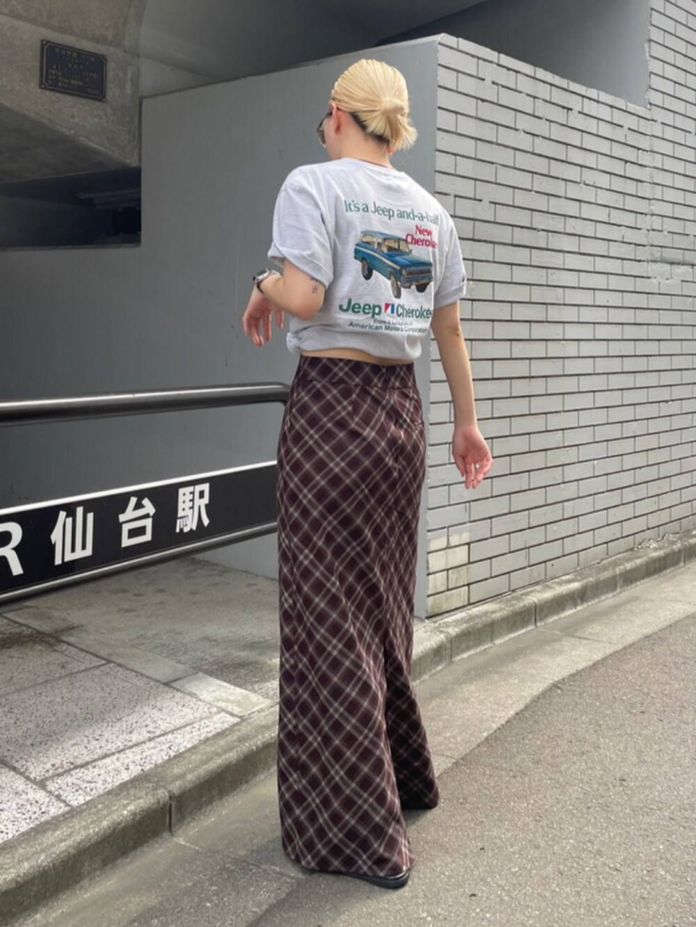 ブラウン系のスカート、グレー系のTシャツ/カットソーを着用したレディースの夏コーディネートの4枚目の写真
