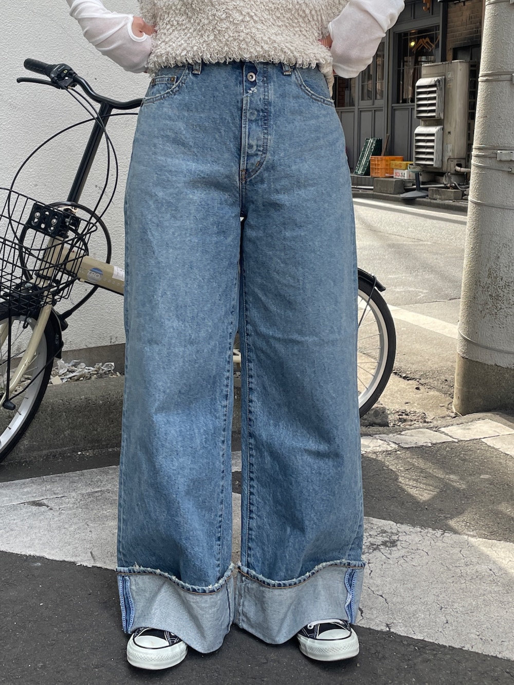 ブルー系のデニムパンツ、ホワイト系のベスト、ホワイト系のTシャツ/カットソーを着用したレディースの冬コーディネートの6枚目の写真