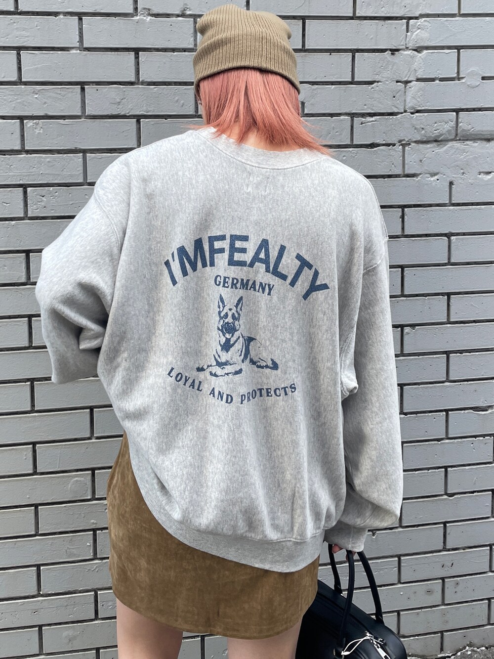 グレー系のスウェット、ベージュ系のスカート、ブラック系のハンドバッグを着用したレディースの秋コーディネートの4枚目の写真