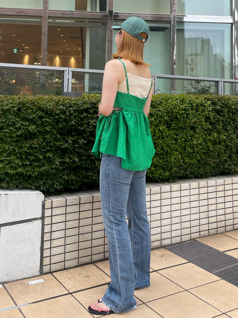 グリーン系のキャミソール、ホワイト系のキャミソール、ブルー系のデニムパンツを着用したレディースの夏コーディネートの2枚目の写真