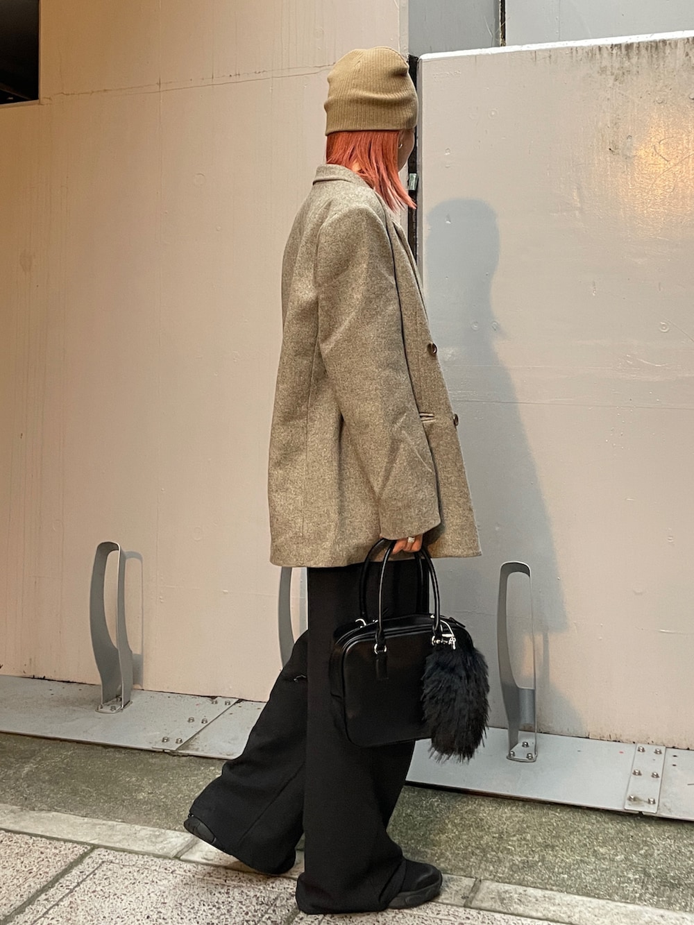 グレー系のテーラードジャケット、グレー系のスウェットパンツ、ブラック系のハンドバッグを着用したレディースの秋コーディネートの2枚目の写真