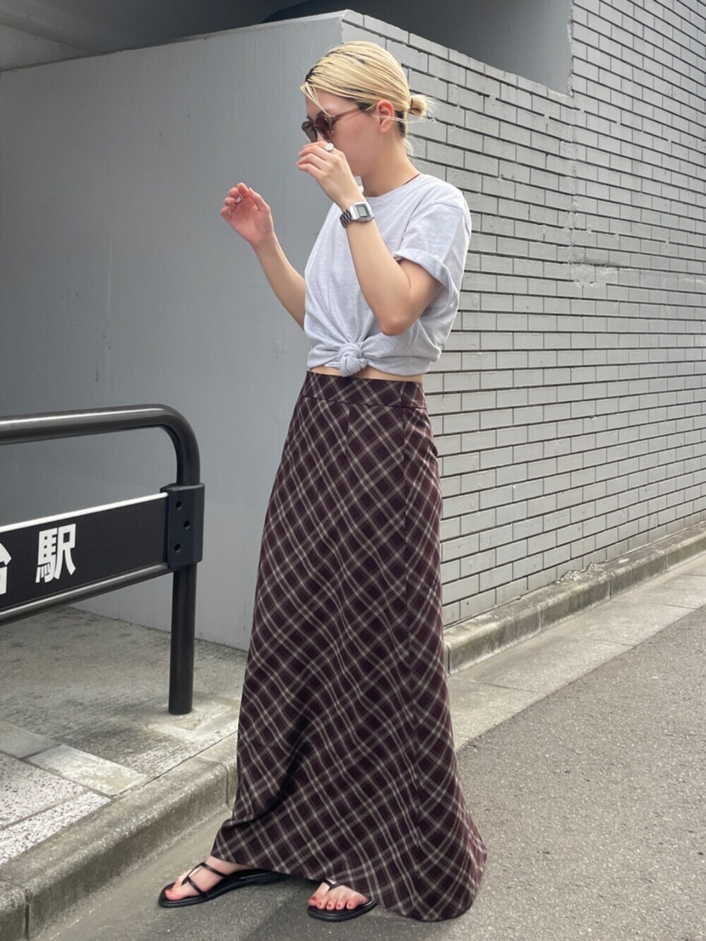 ブラウン系のスカート、グレー系のTシャツ/カットソーを着用したレディースの夏コーディネートの3枚目の写真