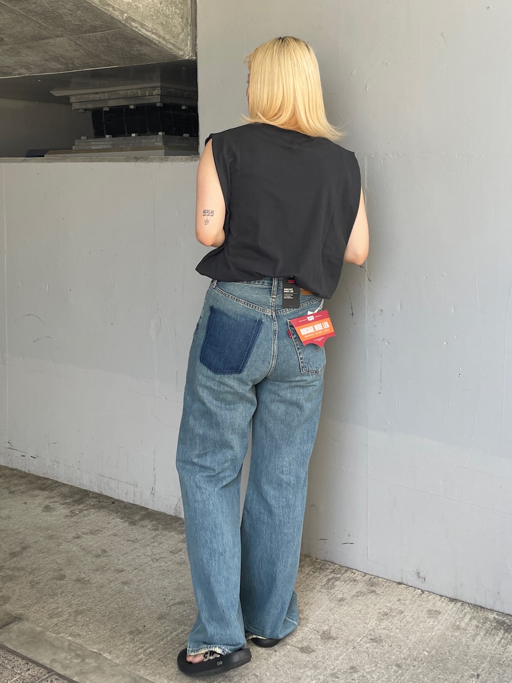 ブルー系のデニムパンツ、グレー系のタンクトップを着用したレディースの夏コーディネートの3枚目の写真