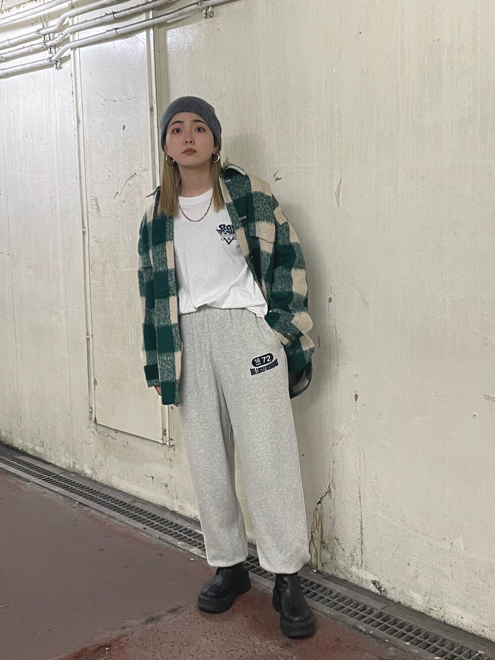 グリーン系のシャツ/ブラウス、ホワイト系のTシャツ/カットソー、ブラック系のブーツを着用したレディースの秋コーディネートの2枚目の写真