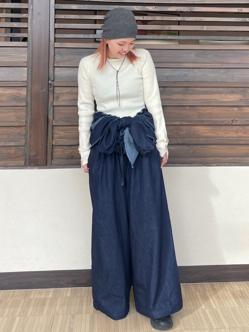 ホワイト系のニット/セーター、ブルー系のつなぎ/オールインワン、ブラック系のネックレスを着用したレディースの秋コーディネートの2枚目の写真