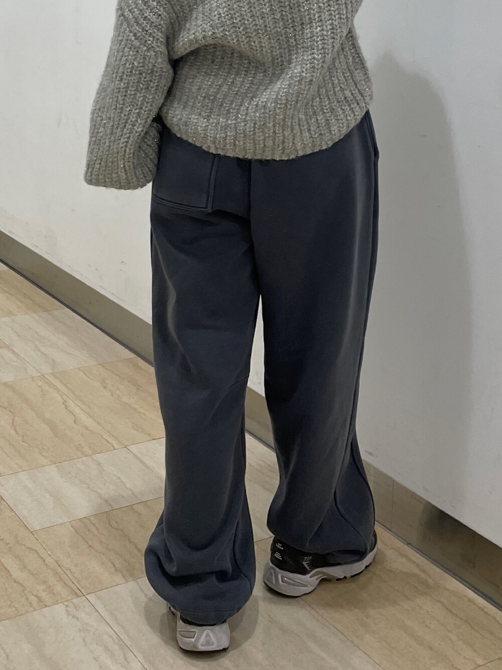 グレー系のニット/セーター、グレー系のスウェットパンツを着用したレディースの冬コーディネートの7枚目の写真