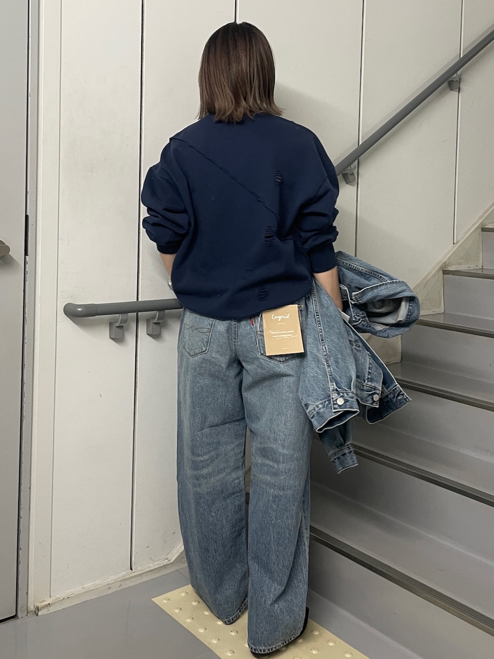 ブルー系のデニムパンツ、ブルー系のデニムジャケット、ブルー系のスウェットを着用したレディースの冬コーディネートの3枚目の写真