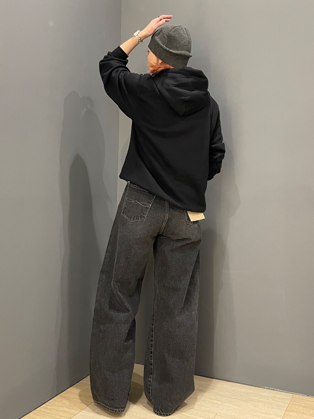 ブラック系のパーカー、ホワイト系のTシャツ/カットソー、ブラック系のデニムパンツを着用したレディースの秋コーディネートの4枚目の写真