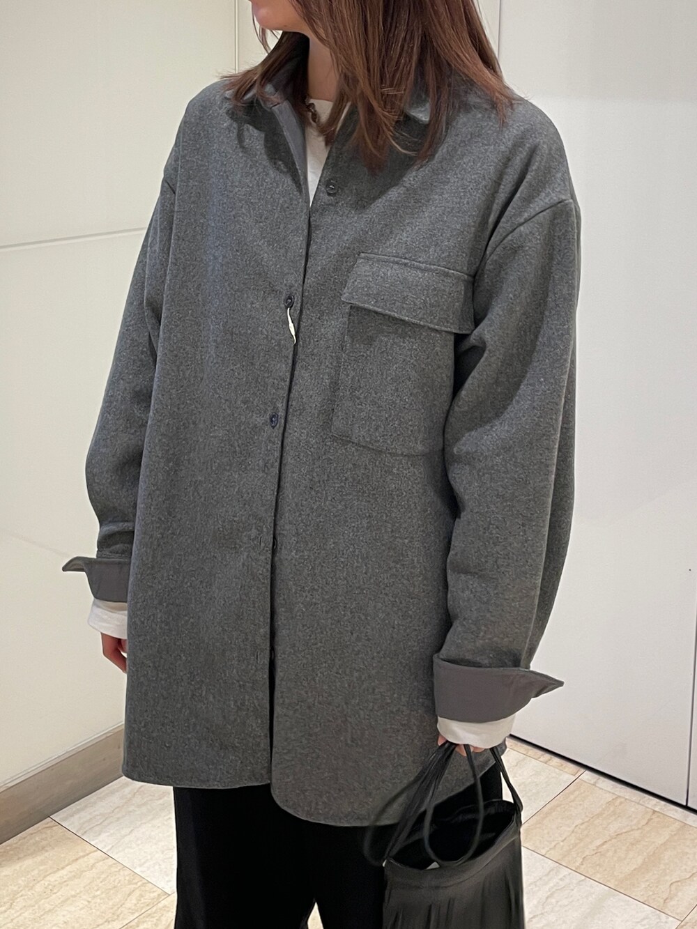グレー系のシャツ/ブラウス、ブラック系のその他パンツ、ホワイト系のTシャツ/カットソーを着用したレディースの秋コーディネートの7枚目の写真