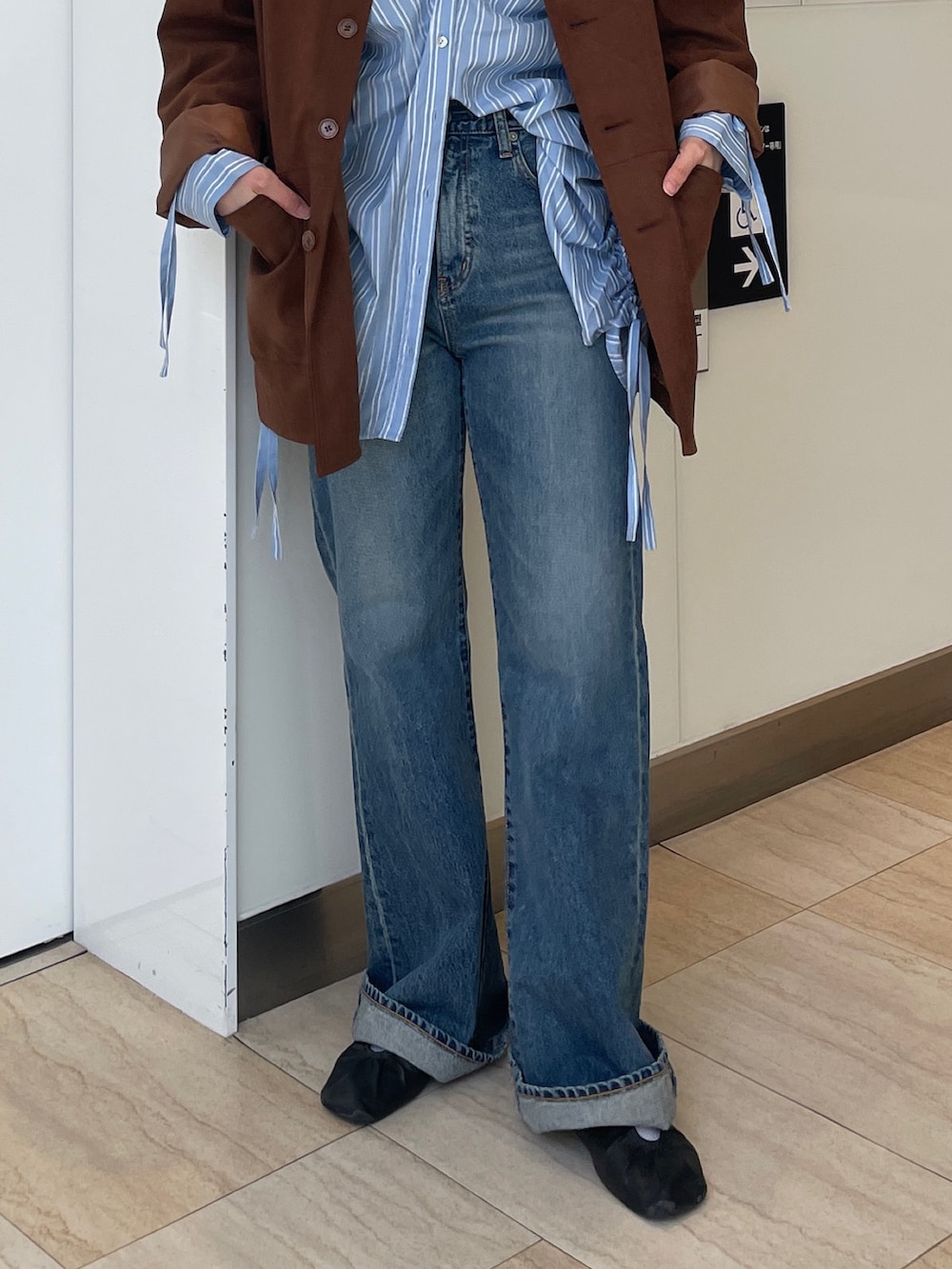 ブラウン系のテーラードジャケット、ブルー系のシャツ/ブラウス、ブルー系のデニムパンツを着用したレディースの春コーディネートの6枚目の写真