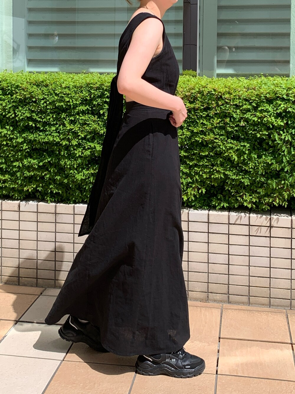 ブラック系のワンピースを着用したレディースの夏コーディネートの2枚目の写真