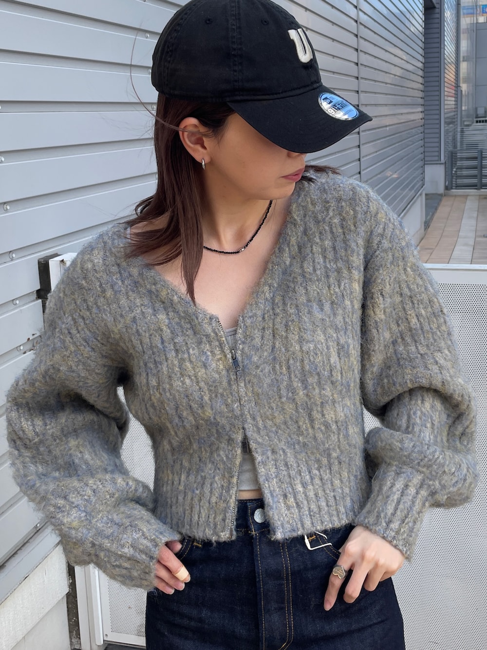 グレー系のニット/セーター、ブルー系のデニムパンツ、ブラック系のネックレスを着用したレディースの秋コーディネートの4枚目の写真