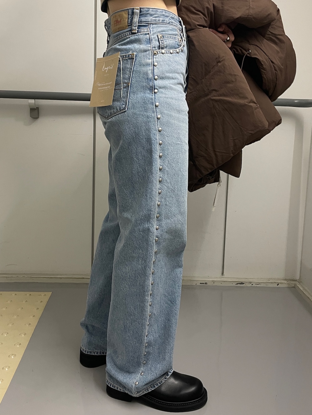 ブルー系のデニムパンツ、ブラック系のブーツ、ブラウン系のダウンジャケット/コートを着用したレディースの秋コーディネートの8枚目の写真