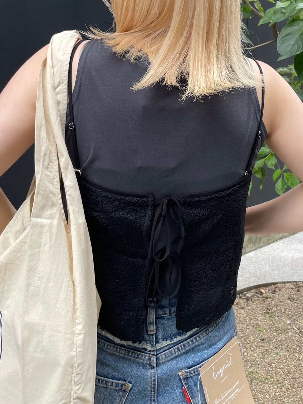 ブルー系のデニムパンツ、ブラック系のタンクトップ、ブラック系のキャミソールを着用したレディースの夏コーディネートの8枚目の写真