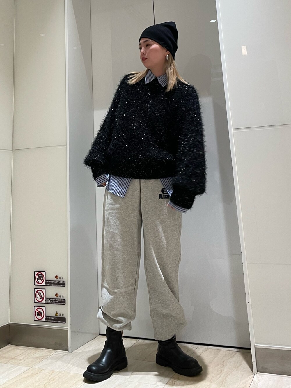 ブラック系のニット/セーター、ブルー系のシャツ/ブラウス、グレー系のスウェットパンツを着用したレディースの秋コーディネートの2枚目の写真