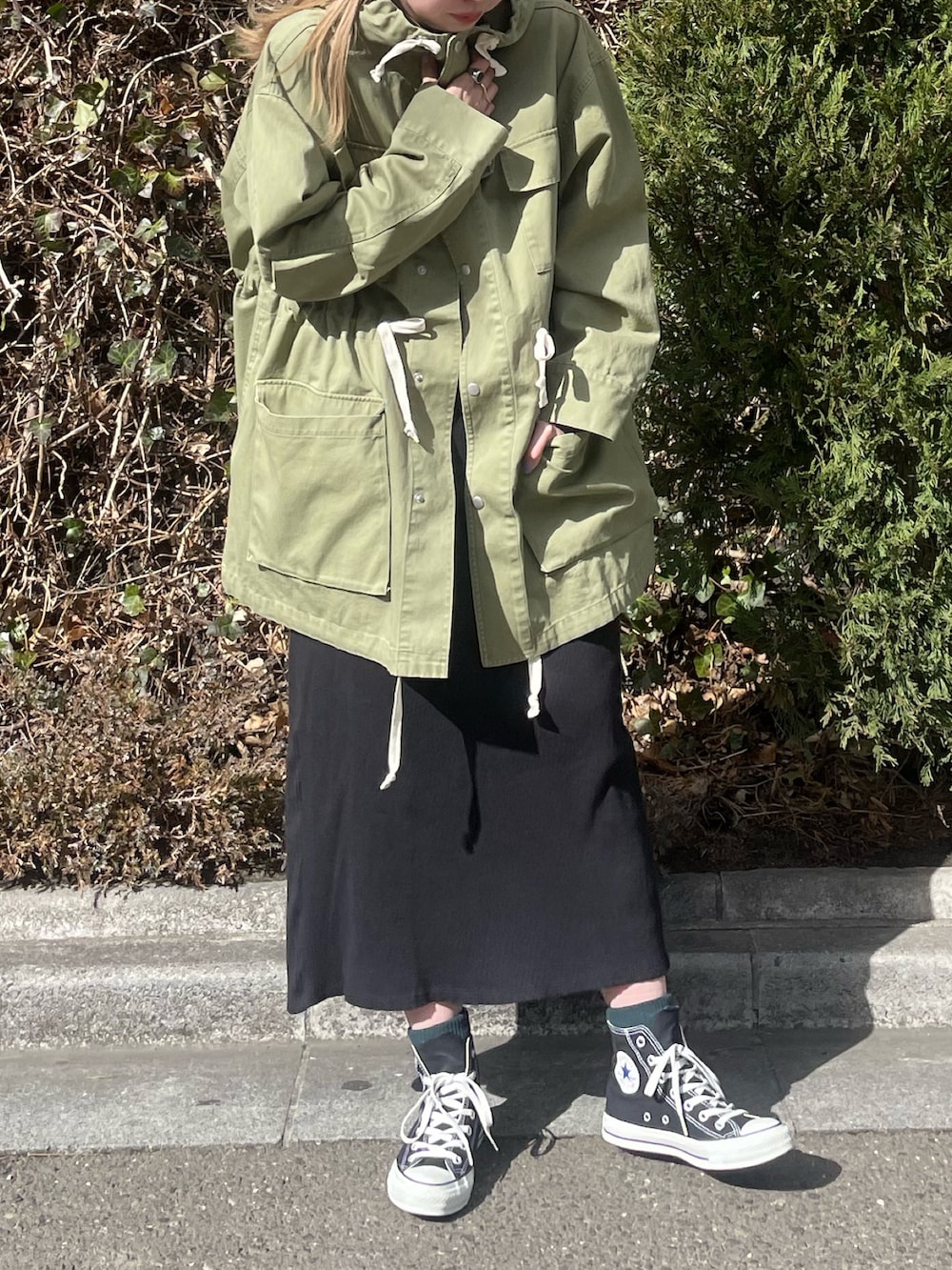 グリーン系のブルゾン、ブラック系のワンピース、ホワイト系のニットキャップ/ビーニーを着用したレディースの冬コーディネートの2枚目の写真