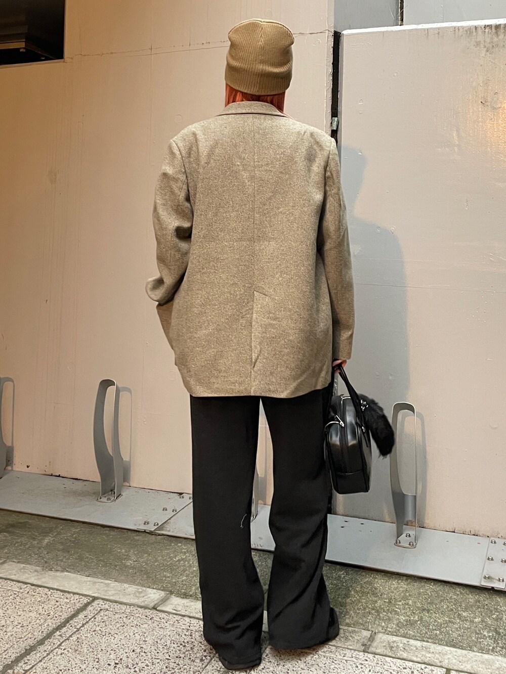 グレー系のテーラードジャケット、グレー系のスウェットパンツ、ブラック系のハンドバッグを着用したレディースの秋コーディネートの3枚目の写真