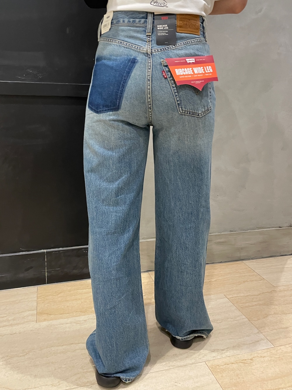 ブルー系のデニムパンツ、ホワイト系のTシャツ/カットソー、ブラック系のハンドバッグを着用したレディースの夏コーディネートの8枚目の写真