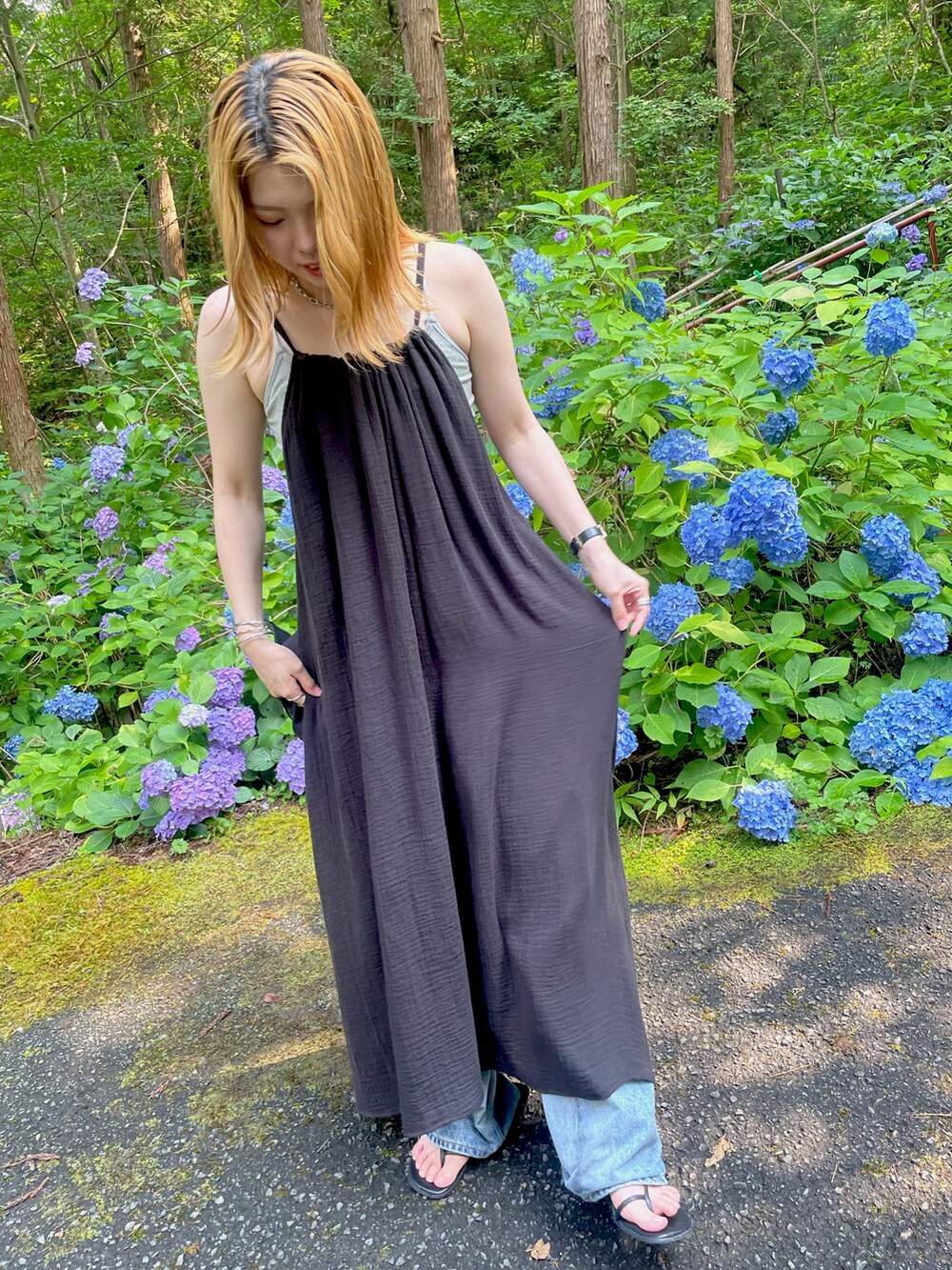 ブラック系のワンピース、ブルー系のデニムパンツ、ブラック系のサンダルを着用したレディースの夏コーディネートの4枚目の写真