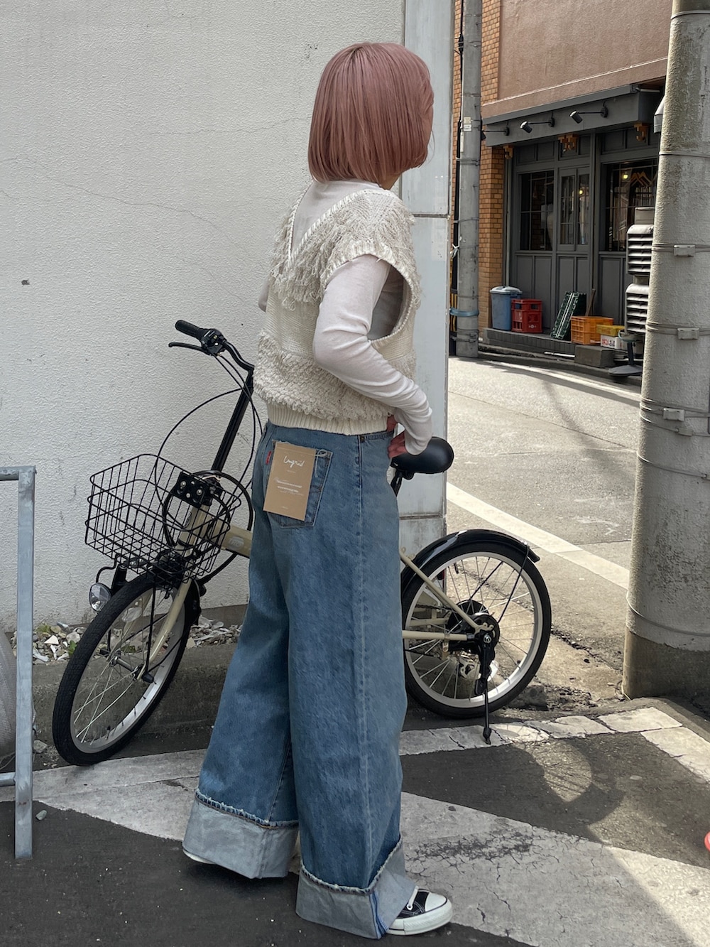 ブルー系のデニムパンツ、ホワイト系のベスト、ホワイト系のTシャツ/カットソーを着用したレディースの冬コーディネートの2枚目の写真