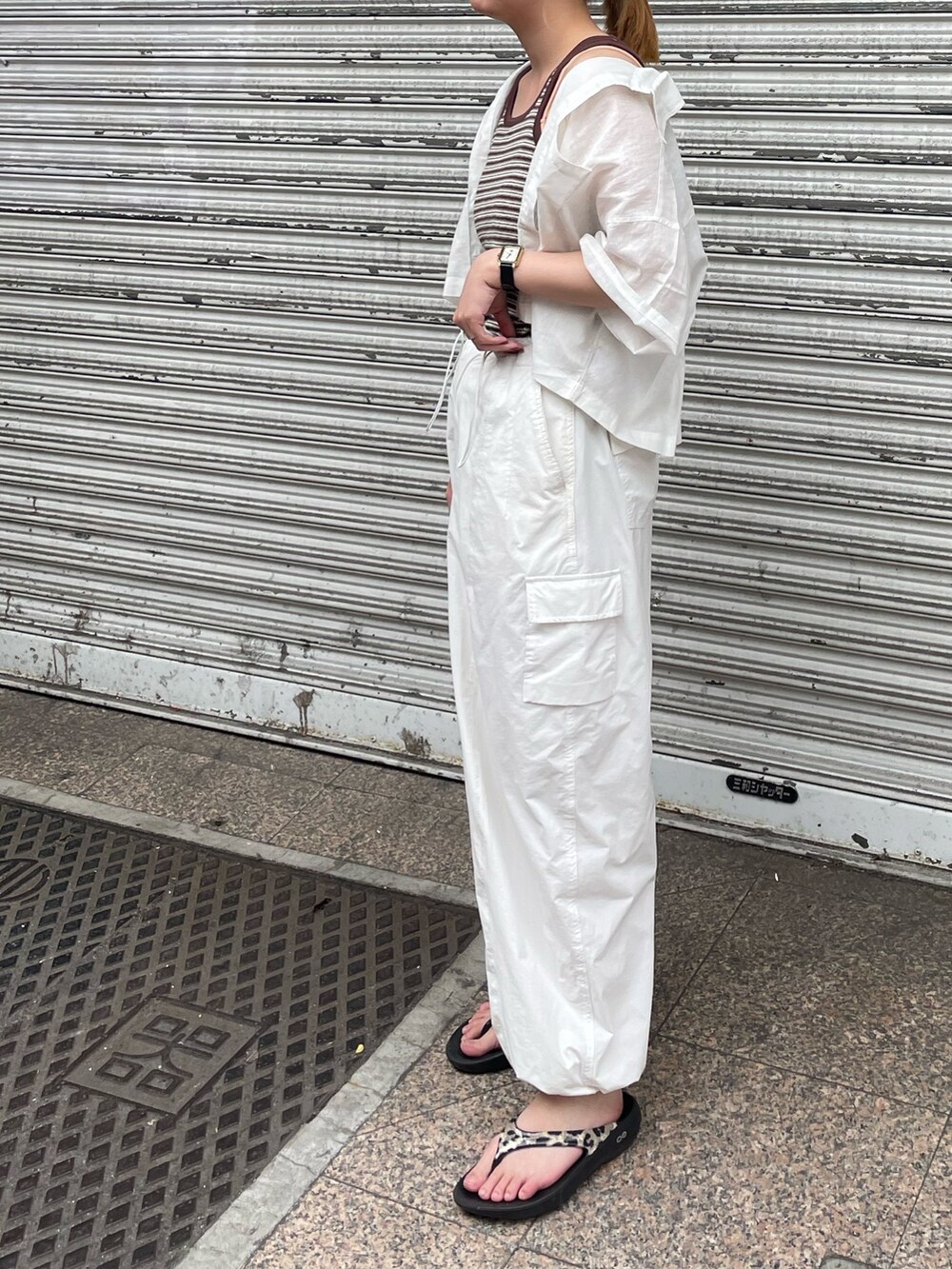 ホワイト系のカーゴパンツ、ブラウン系のタンクトップ、ホワイト系のシャツ/ブラウスを着用したレディースの夏コーディネートの2枚目の写真