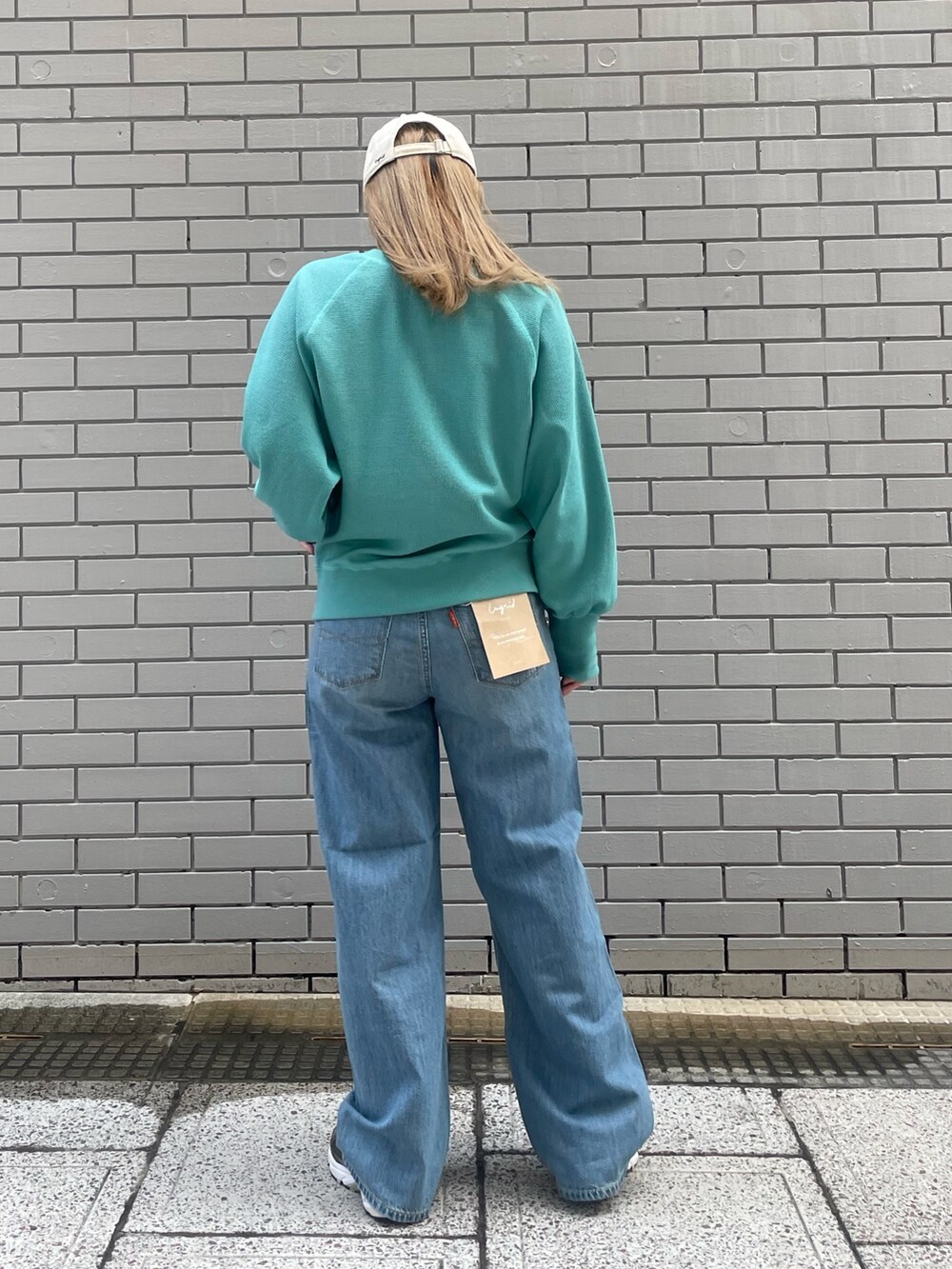 ブルー系のカーディガン/ボレロ、ブルー系のデニムパンツ、ホワイト系のキャップを着用したレディースの冬コーディネートの4枚目の写真