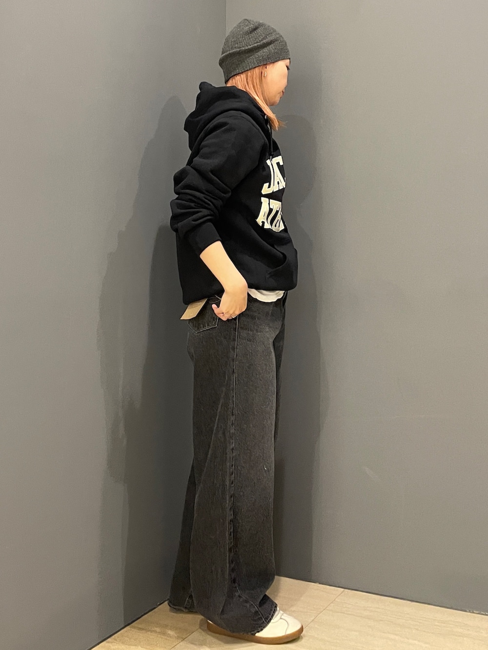 ブラック系のパーカー、ホワイト系のTシャツ/カットソー、ブラック系のデニムパンツを着用したレディースの秋コーディネートの3枚目の写真